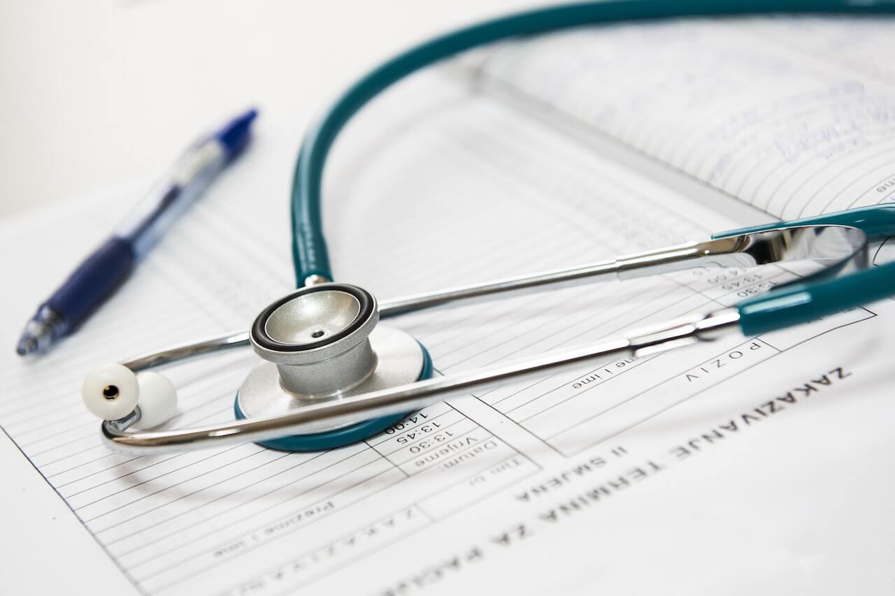 Stethoscope and pen sitting on top of papers